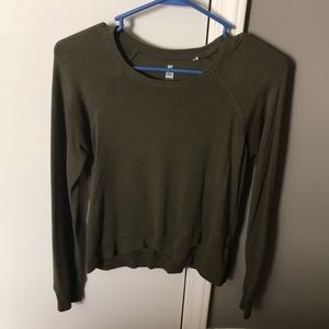 Green, long-sleeved sweater. Shows a little tummy